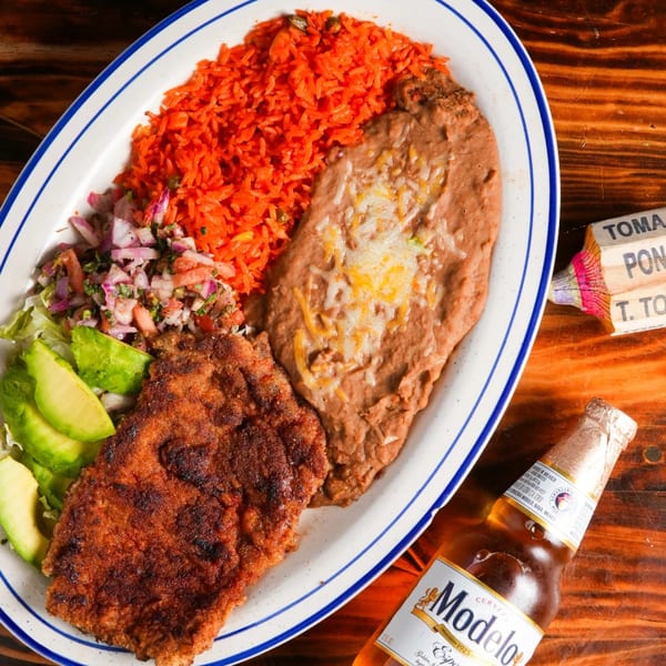 El Mezcal's breaded steak with red rice, refried beans, pico de gallo, avocado, and a Modelo beer.